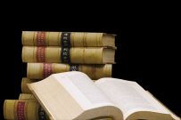 A stack of old law reports on a black background.