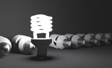 Standing spiral light bulb in row of lying ones