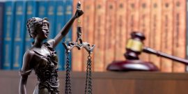 Lady Justice with books behind