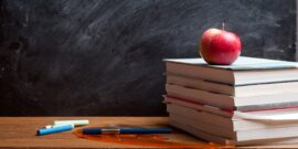 school books and chalkboard_shutterstock_154985321